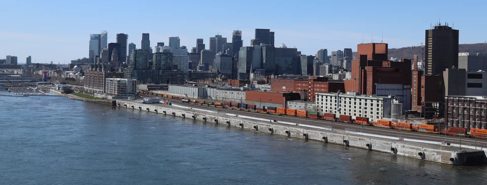 Quai du port de Montréal avec des trains de conteneurs et le centre-ville en arrière-plan